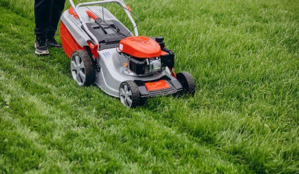 man-cutting-grass-with-lawn-mover-back-yard_1303-22794